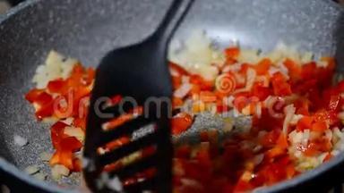 炒锅与切碎的洋葱和胡椒在热板